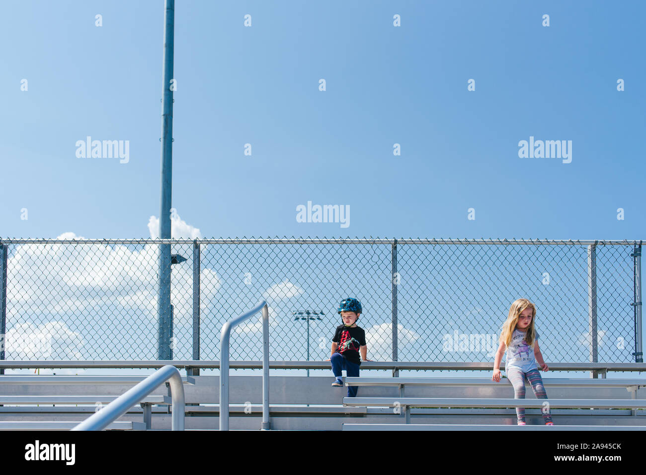 Zwei Kinder sitzen an der Spitze der Zuschauertribünen. Stockfoto