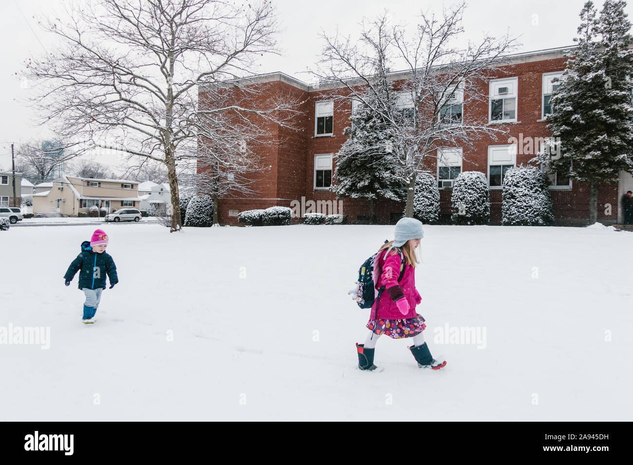 Zwei Kinder gehen im Schnee zur Schule. Stockfoto