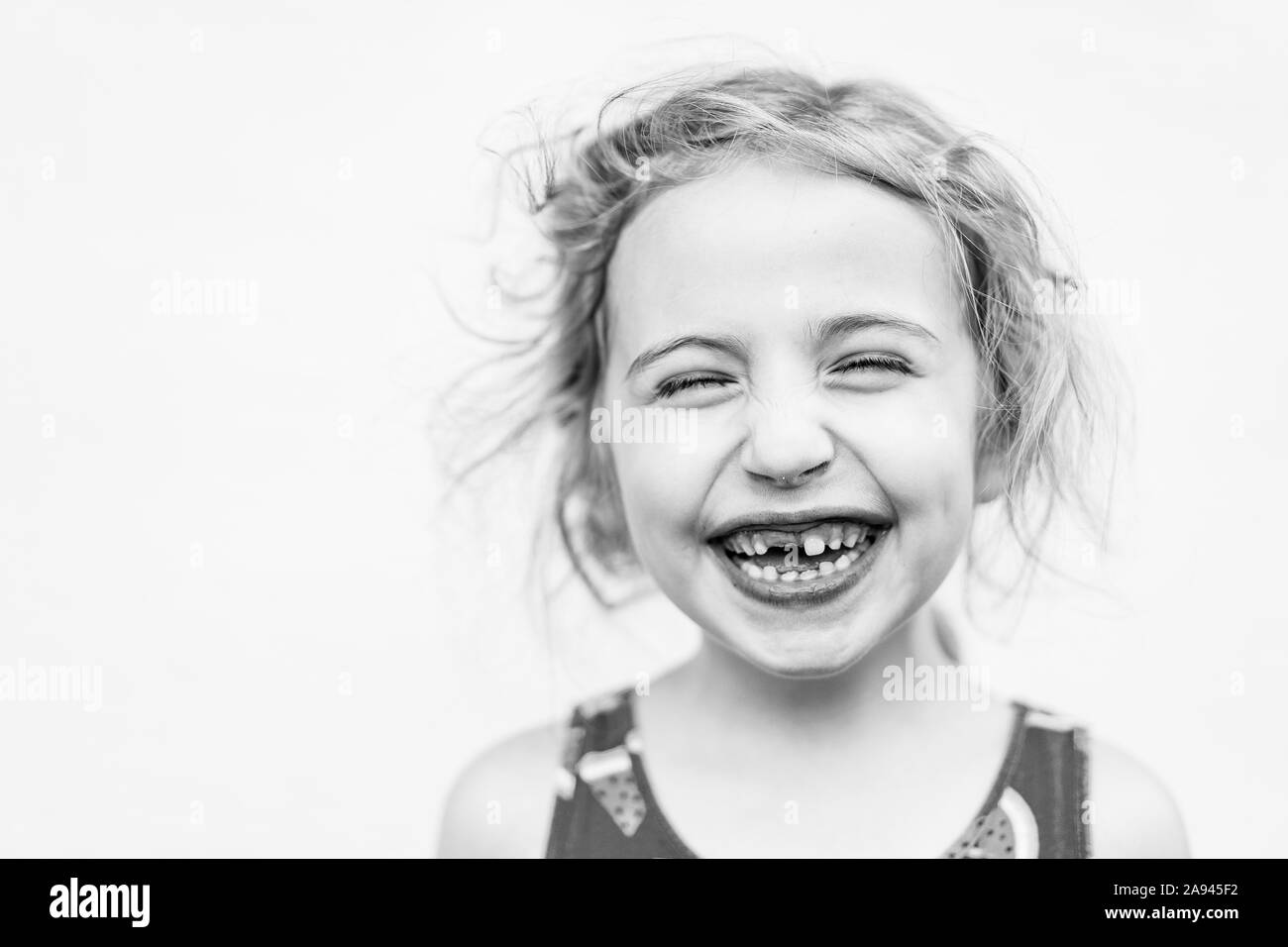 Ein Porträt von einem kleinen Mädchen fehlt Ihrem vorderen Zahn. Stockfoto