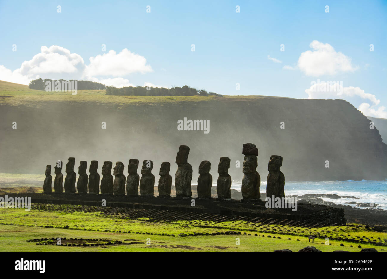 Die fünfzehn Moais von Tongariki aus der Ferne gesehen in abnehmender Perspektive gegen den Ozean und blauen Himmel; Osterinsel, Chile Stockfoto
