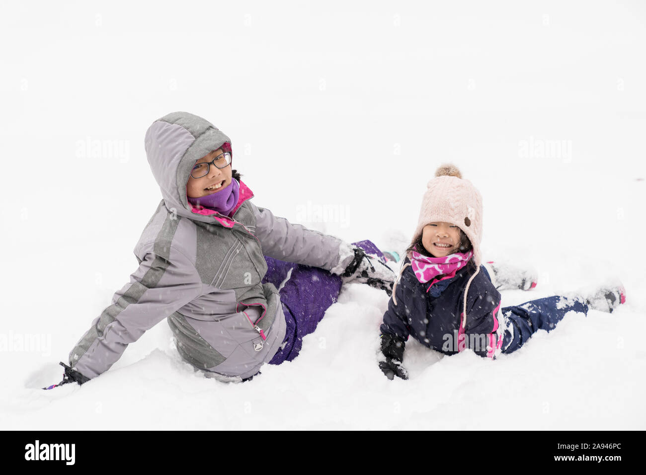 Zwei kleine Kinder spielen im Schnee. Stockfoto