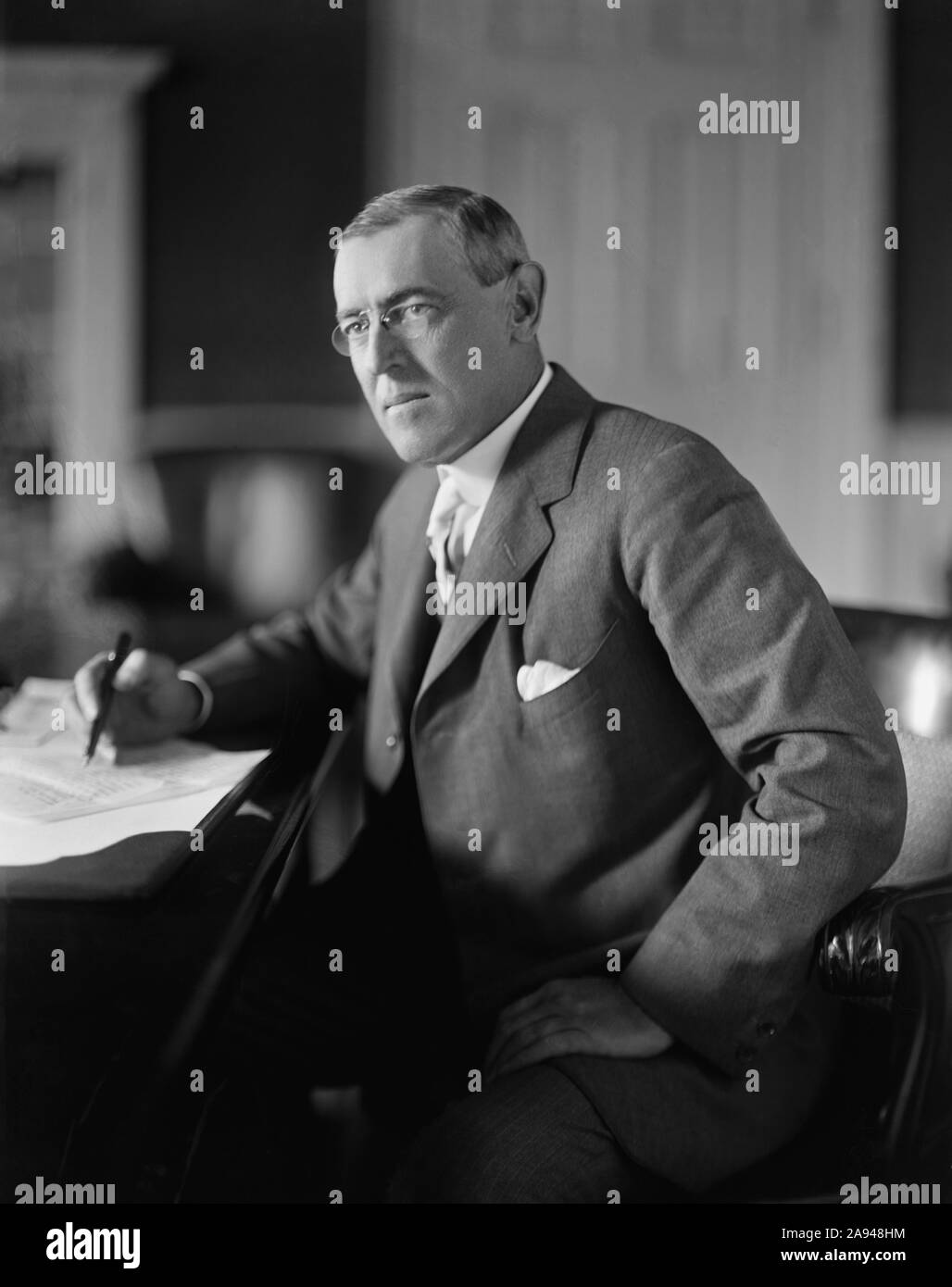 Us-Präsident Woodrow Wilson sitzt am Schreibtisch im Oval Office des Weißen Hauses während seiner ersten Amtszeit, Washington, D.C., USA, Harris & Ewing, zwischen 1913 und 1916 Stockfoto
