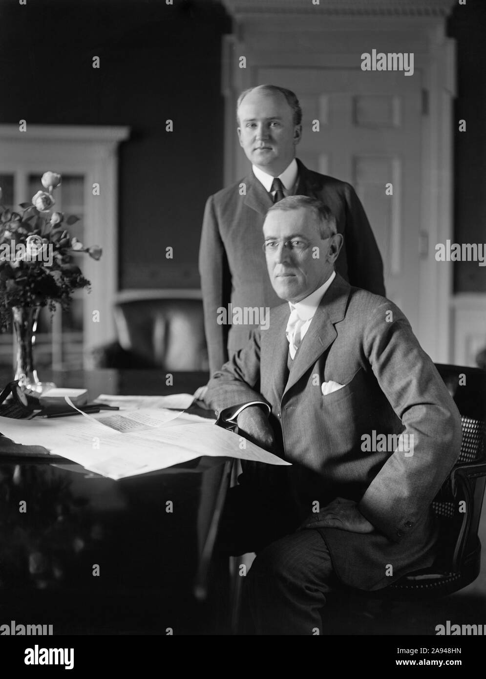 Us-Präsident Woodrow Wilson sitzt am Schreibtisch im Oval Office des Weißen Hauses mit seinem Privatsekretär Joseph Patrick Tumulty standen während Wilson der erste Term in Office, Washington, D.C., USA, Harris & Ewing, zwischen 1913 und 1916 Stockfoto