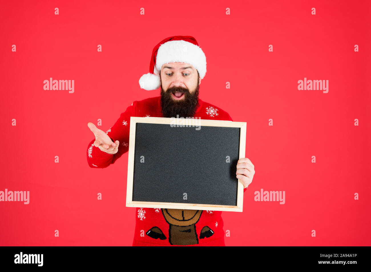Unglaublich. Santa Claus hat mit Werbung. Schwarzes Brett für Informationen. Mann leere Tafel kopieren. Guy santa claus roten Hintergrund. Winter Ankündigung. Winter event. Winterurlaub. Stockfoto