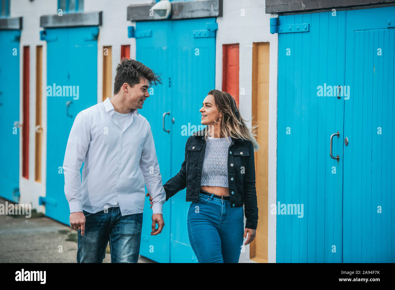 Porträt eines jungen Paares, das Zuneigung zeigt, während sie zusammen spazieren; Wellington, Nordinsel, Neuseeland Stockfoto