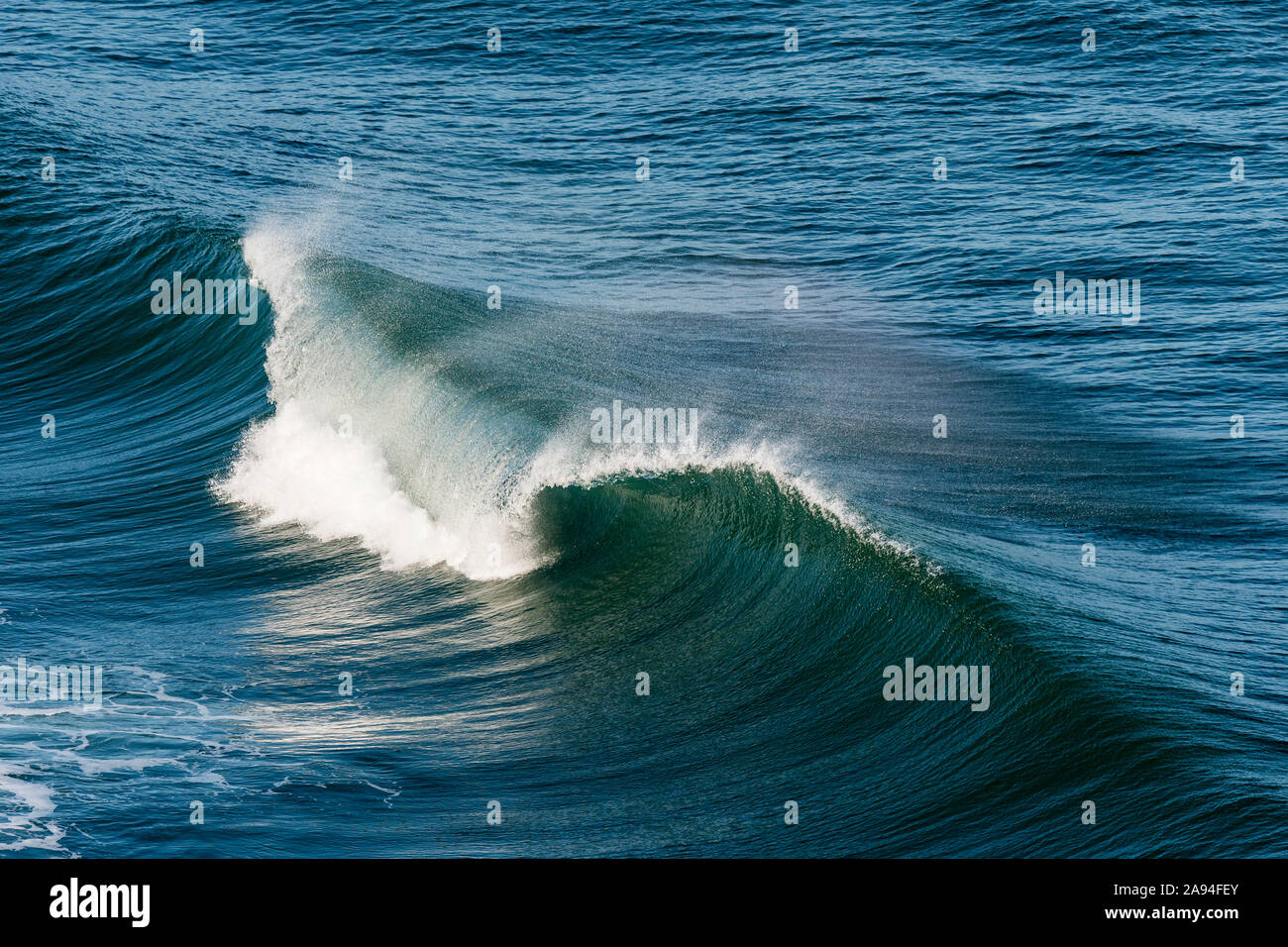 Eine Welle bricht in eine anmutige Locke am Cape Disappointment State Park; Ilwaco, Washington, Vereinigte Staaten von Amerika Stockfoto