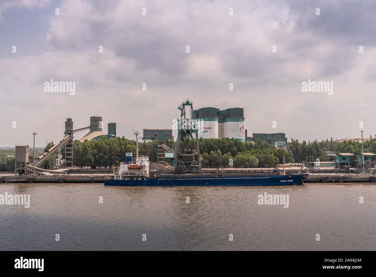 Lange Tau Fluss, Vietnam - 12. März 2019: Nhon Trach. Direkter Blick auf das Boot zu INSEE Zement station mit Silos, Förderbänder, und seine qu Stockfoto