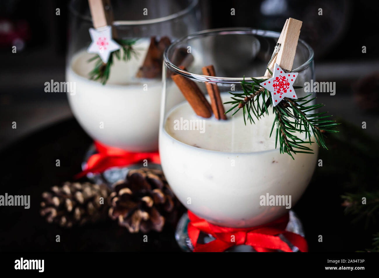 Ein traditionelles Eierlikör Weihnachten Drink in ein Glas Becher dekoriert mit neuen Jahr Wäscheklammer. Nicht-alkoholische Option. Stimmungsvolle Fotos. Stockfoto