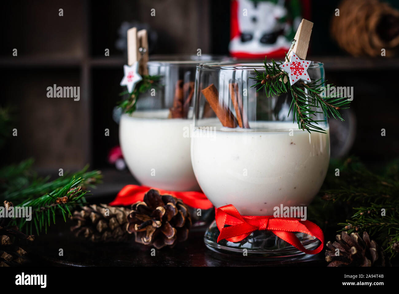 Ein traditionelles Eierlikör Weihnachten Drink in ein Glas Becher dekoriert mit neuen Jahr Wäscheklammer. Nicht-alkoholische Option. Stimmungsvolle Fotos. Stockfoto