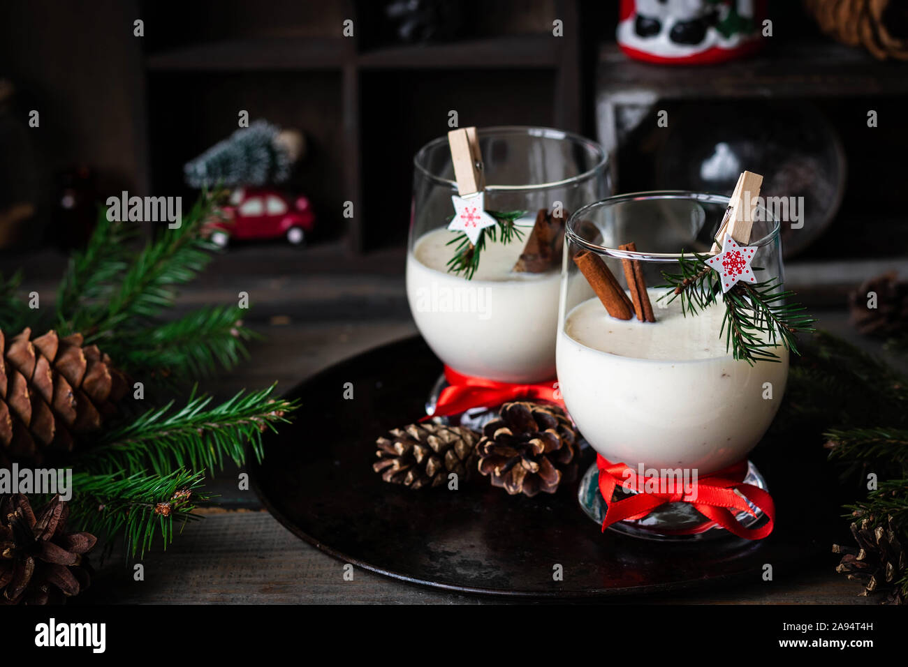 Ein traditionelles Eierlikör Weihnachten Drink in ein Glas Becher dekoriert mit neuen Jahr Wäscheklammer. Nicht-alkoholische Option. Stimmungsvolle Fotos. Stockfoto