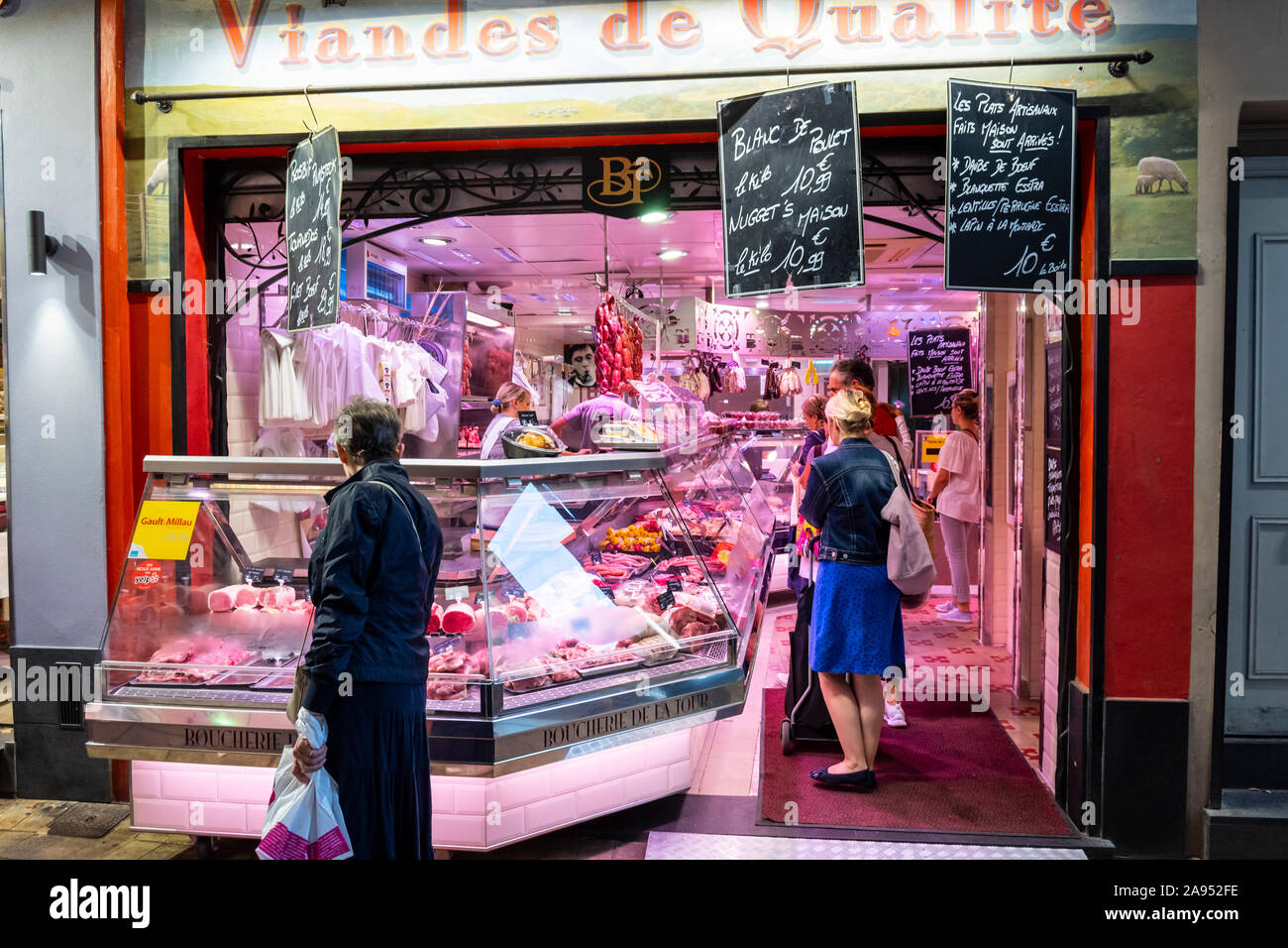 Kunden Warten am Schalter zum Metzgerei Meat Market am frühen Abend in der Altstadt von Nizza, Frankreich. Stockfoto