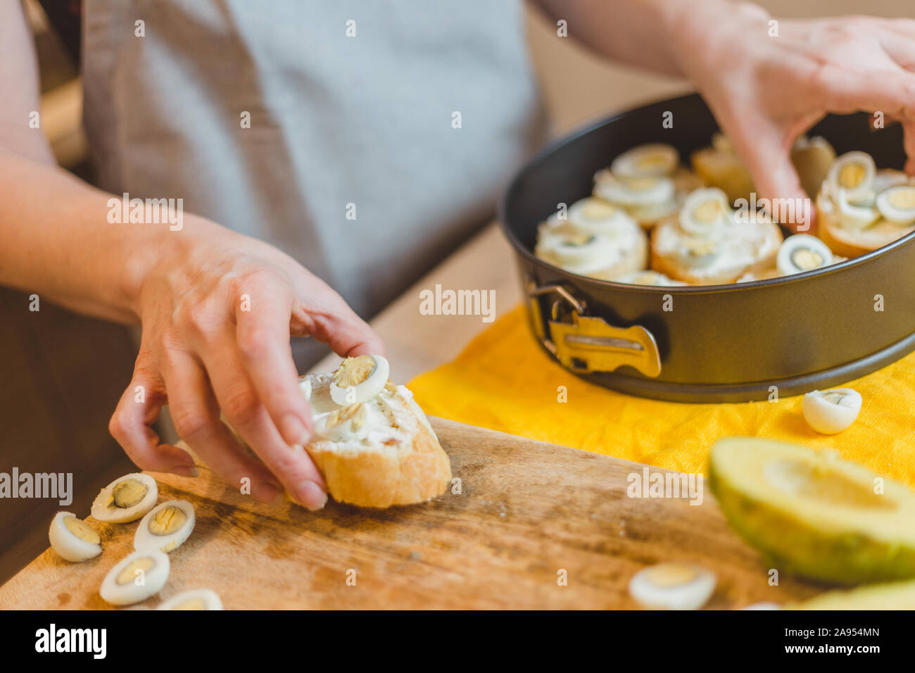 Nahaufnahme der älteren Frau Hände schneiden Baguette, Sandwich Bruschetta - Home Cooking Stockfoto