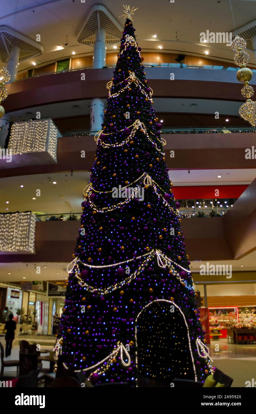 Dekoriert künstlicher Weihnachtsbaum in einem Einkaufszentrum mit vielen schönen Beleuchtung Lampen und Girlanden, Sofia, Bulgarien Stockfoto