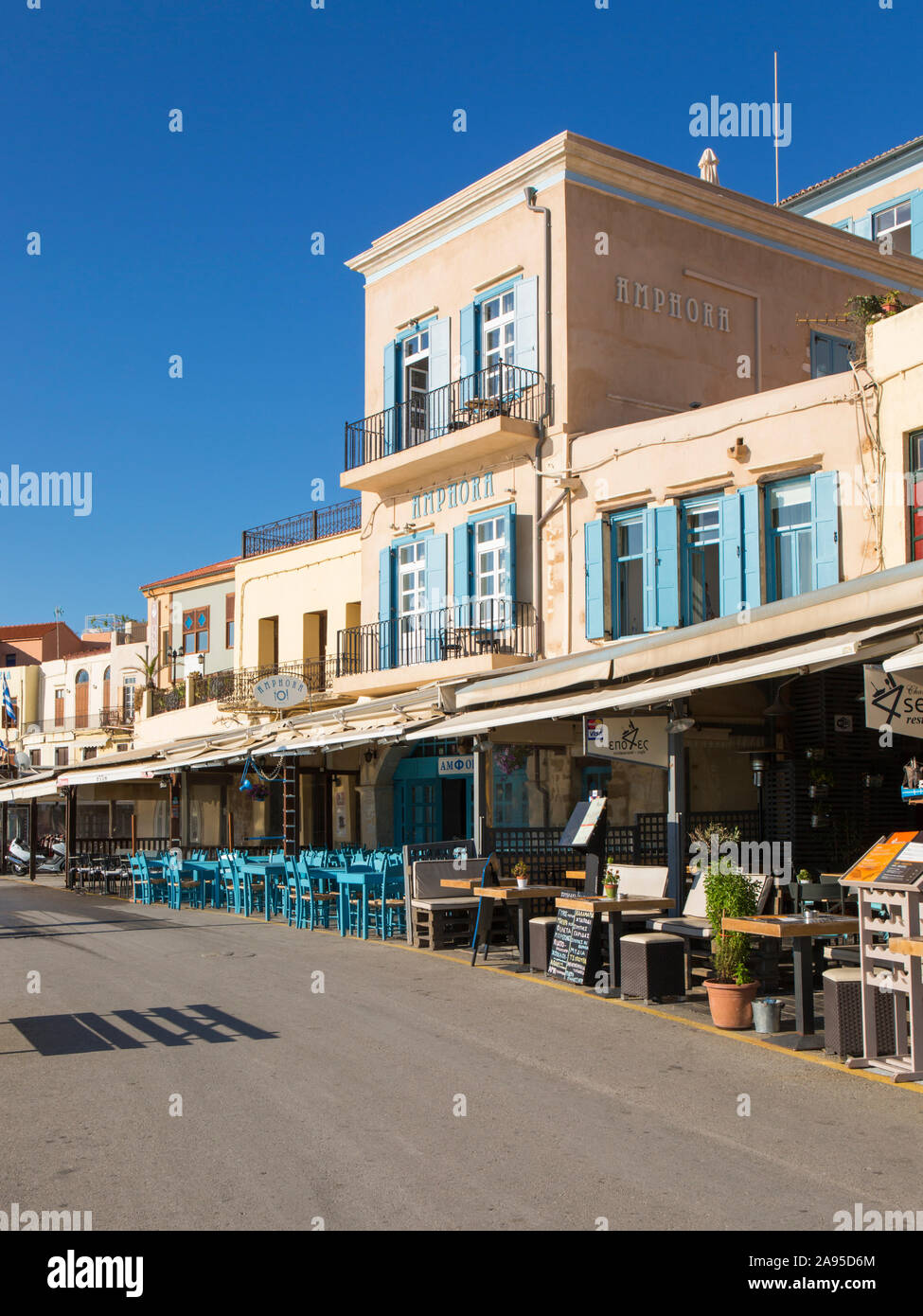 Chania, Kreta, Griechenland. Farbenfrohe Hotels und Cafés am Wasser entlang des venezianischen Hafens. Stockfoto