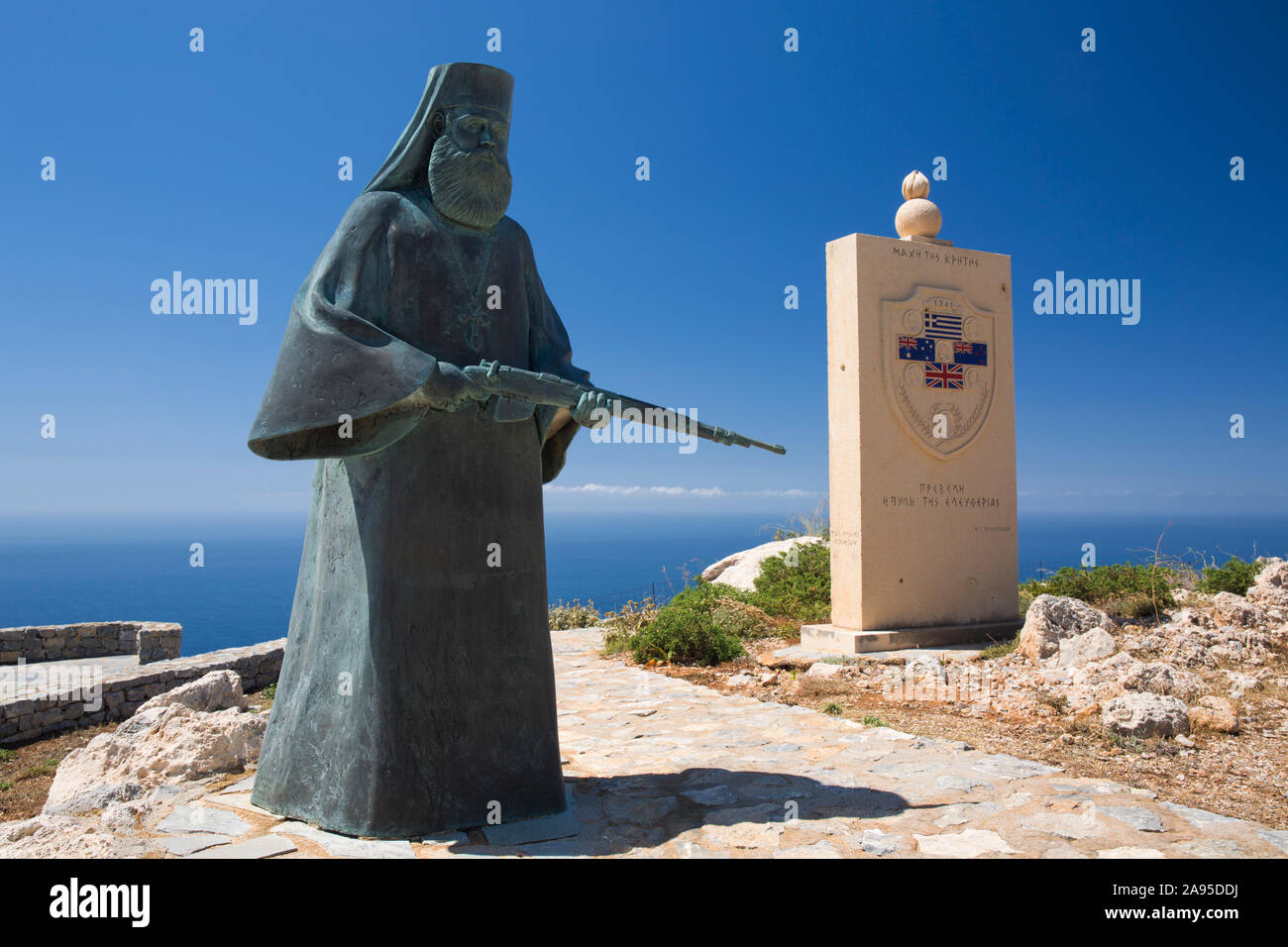 Preveli, Rethymno, Kreta, Griechenland. Kriegsdenkmal mit der Figur eines bewaffneten Mönchs in der Nähe des Oberen Preveli Klosters. Stockfoto
