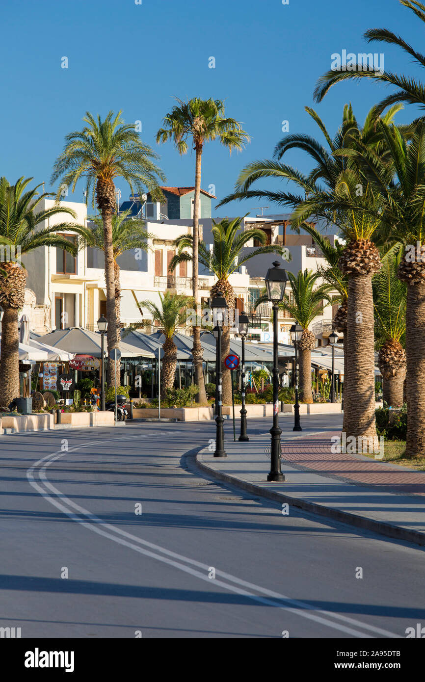 Rethymno, Kreta, Griechenland. Blick entlang der palmengesäumten Strandpromenade, am frühen Morgen. Stockfoto