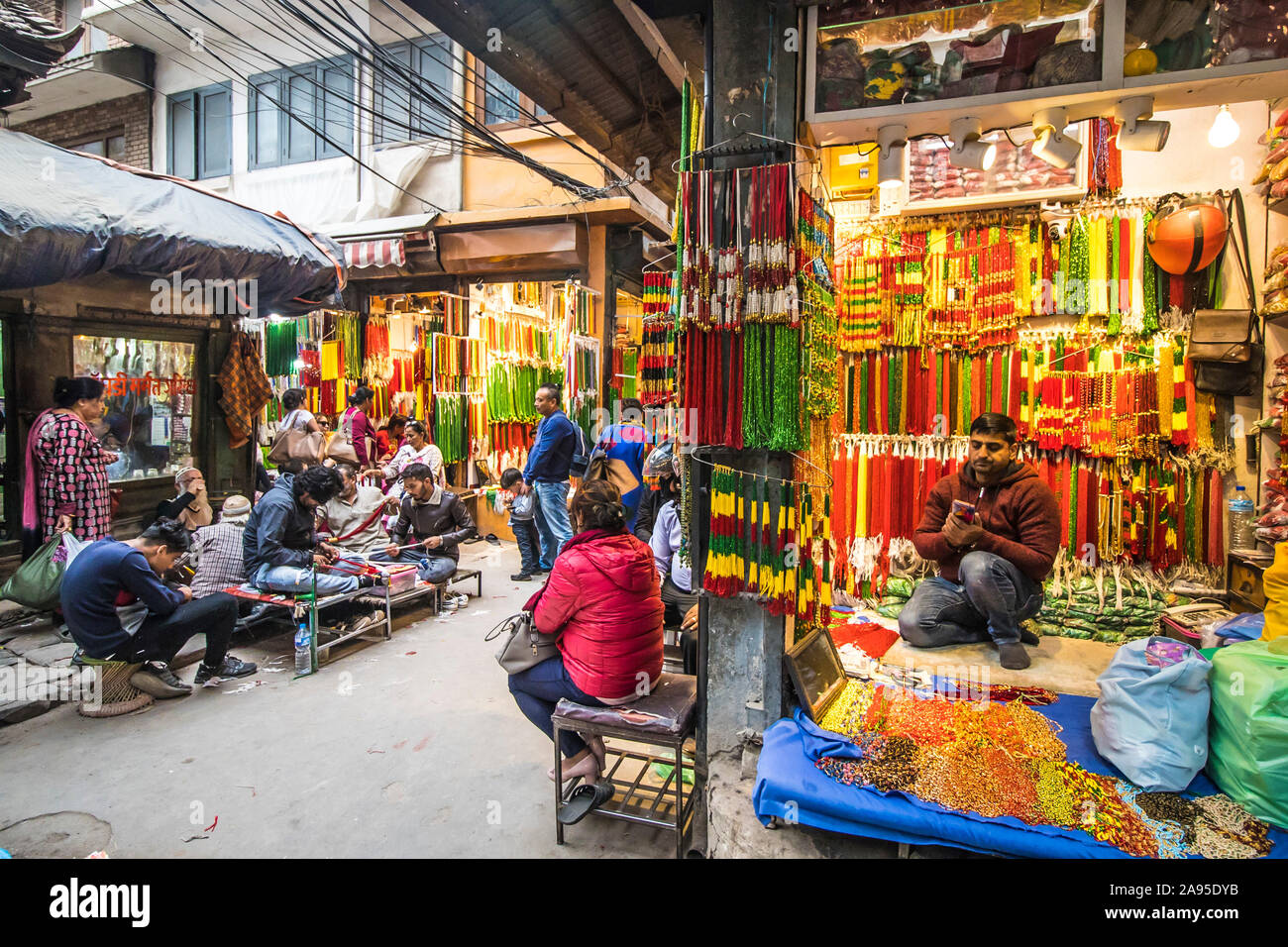 Das Hotel liegt an einer Seitenstraße in Kathmandu, Nepal, gesäumt mit Läden für coloful Perlen mit jungen Männern Aufreihen der Perlen beim Kunden auf Stühlen warteten. Stockfoto
