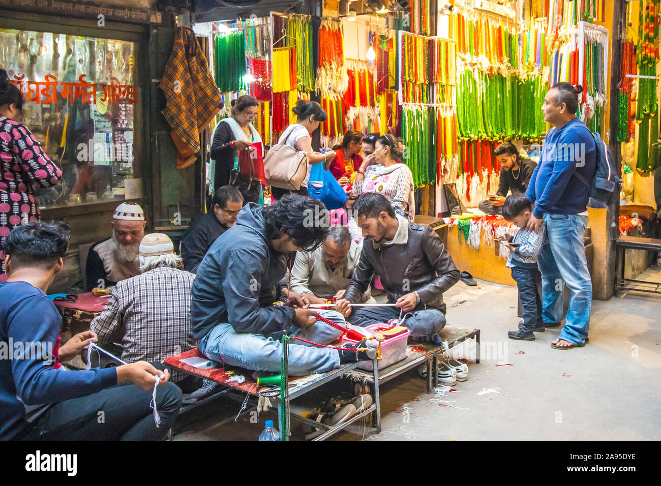 Das Hotel liegt an einer Seitenstraße in Kathmandu, Nepal, gesäumt mit Läden für coloful Perlen mit jungen Männern Aufreihen der Perlen beim Kunden auf Stühlen warteten. Stockfoto