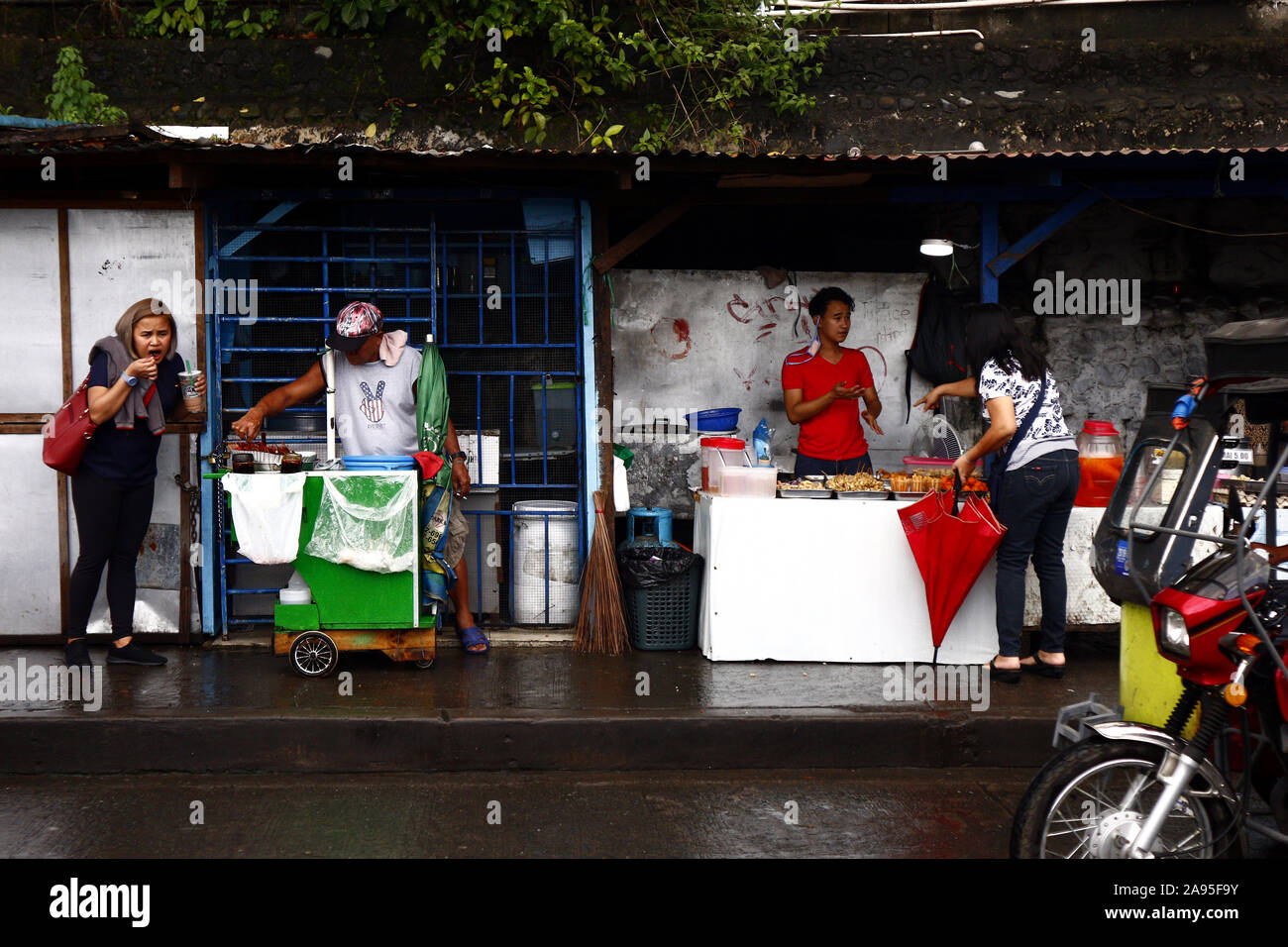 ANTIPOLO CITY, Philippinen - 12. NOVEMBER 2019: Bürgersteig Händler verkaufen Street Food an Kunden und Passanten auf der Straße. Stockfoto