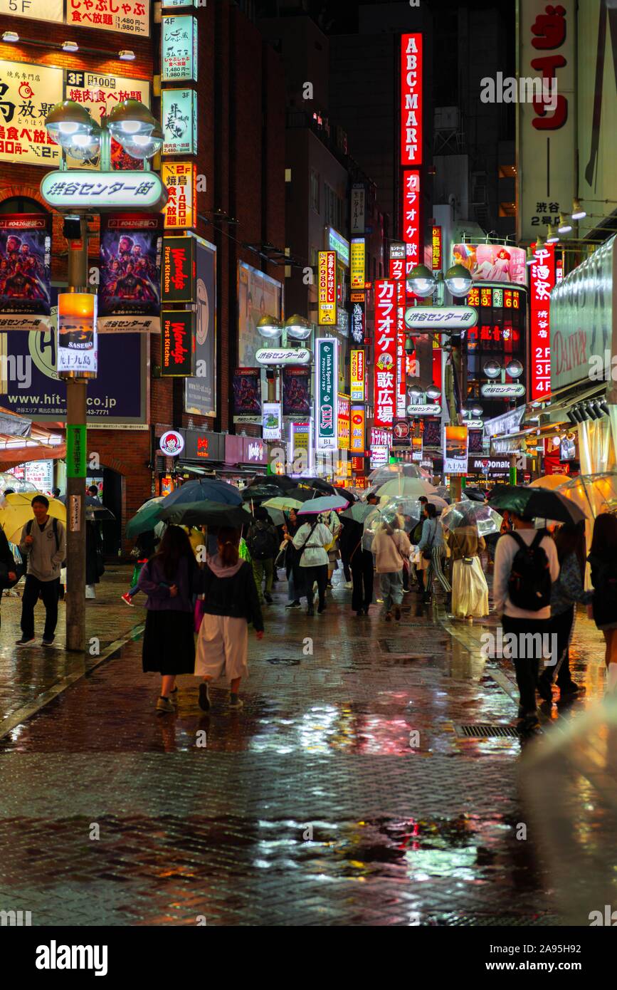 Menschen im Regen in der Fußgängerzone, beleuchtete Werbung bei Nacht, Udagawacho Straße, Shibuya, Tokio, Japan Stockfoto