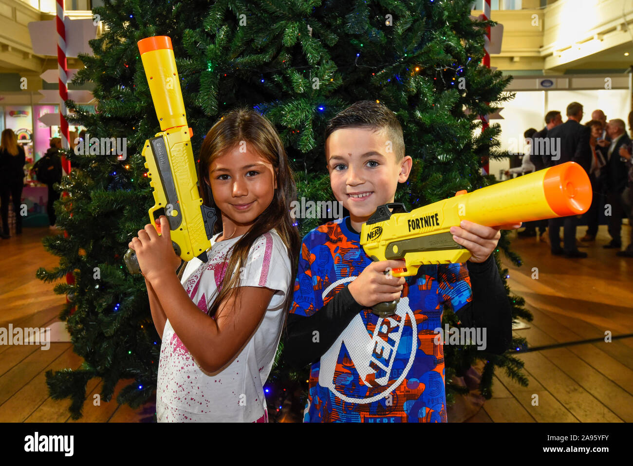 London, Großbritannien. 13. November 2019. Ayva (7 Jahre) und Joshua (ab 8)  Spielen Sie mit Nerf Elite Fortnite SP-L Nerf Guns von Hasbro auf  'DreamToys', der offiziellen Spiele und Spielwaren Weihnachten Vorschau,
