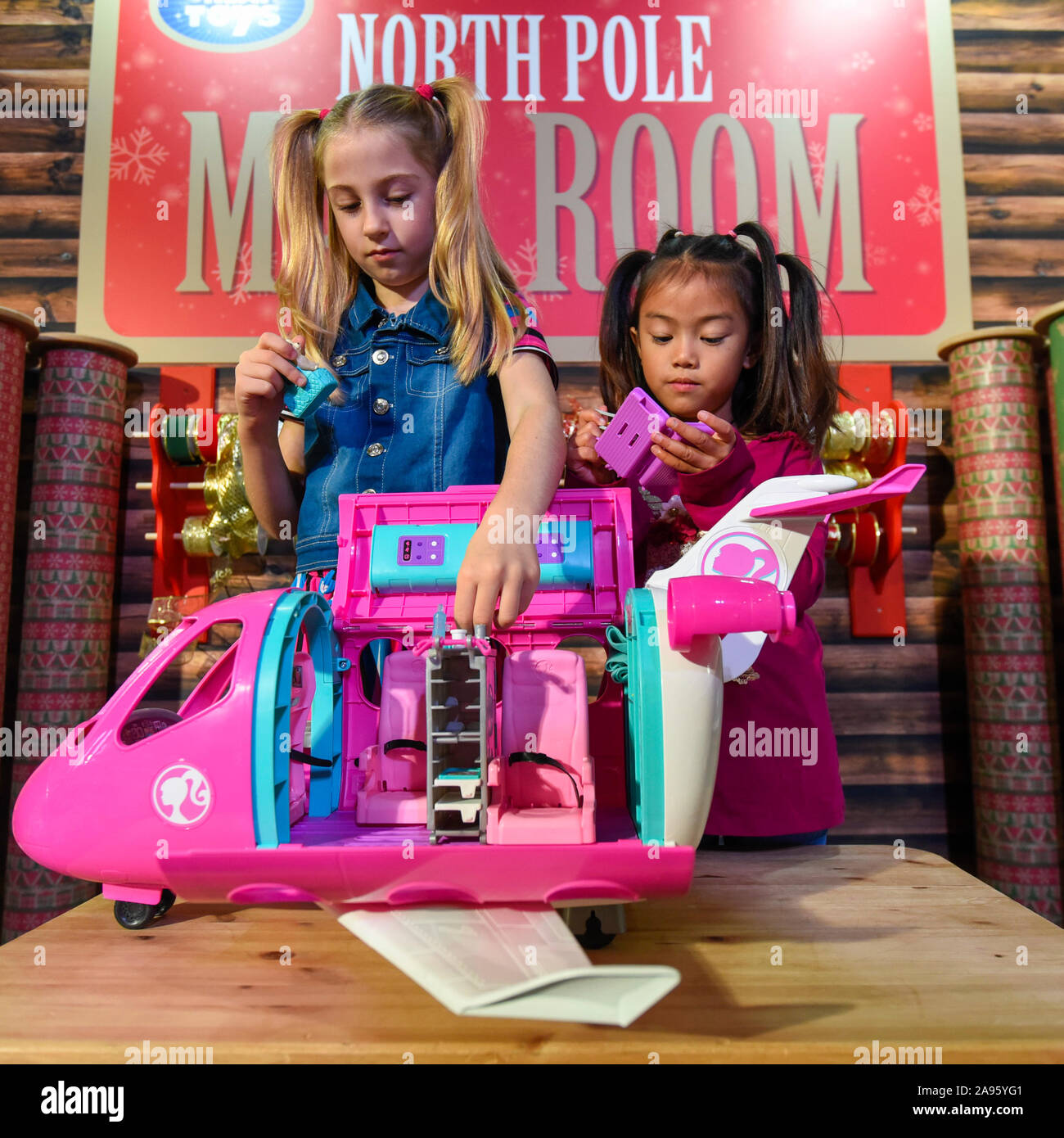 London, Großbritannien. 13. November 2019. (L und R) Liana (7 Jahre) und  Trilyna (ab 6 Jahren) spielen mit Barbie von Mattel Dreamplane  Spielplatzgeräte auf 'DreamToys', der offiziellen Spiele und Spielwaren  Weihnachten Vorschau,