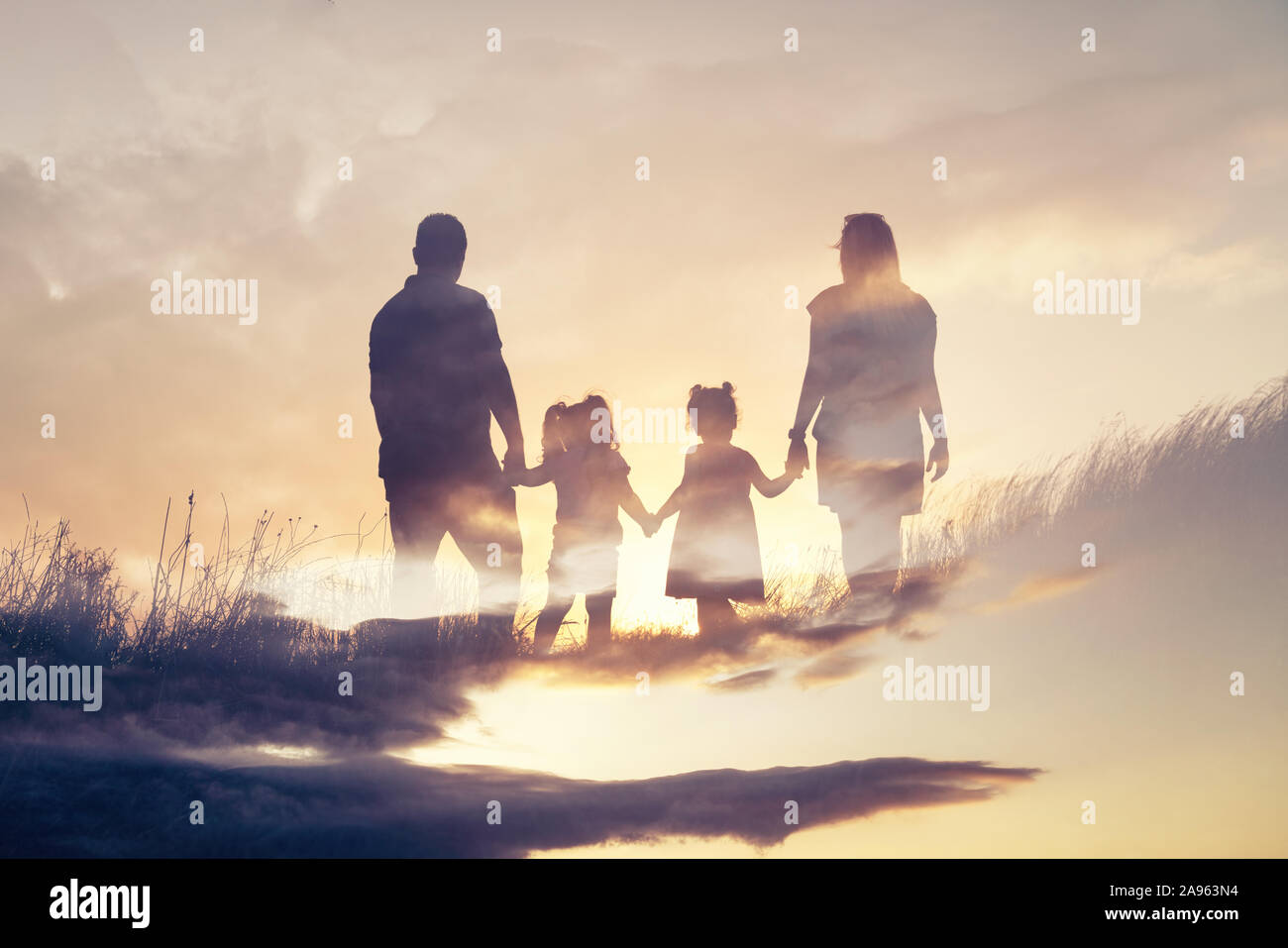 Glückliche Familie Silhouette stehen auf gegen Sonnenuntergang. Stockfoto Glückliche Familie Silhouette stehen auf gegen Sonnenuntergang. Stockfoto