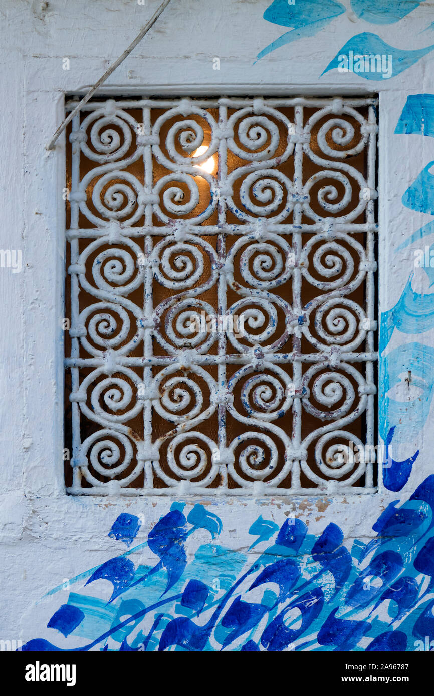 Asilah, Morocco-September 10, 2019: marokkanischen Design Fenster mit Metall Geländer und Wandmalerei Kunst in Ouarzazate, Marokko Stockfoto