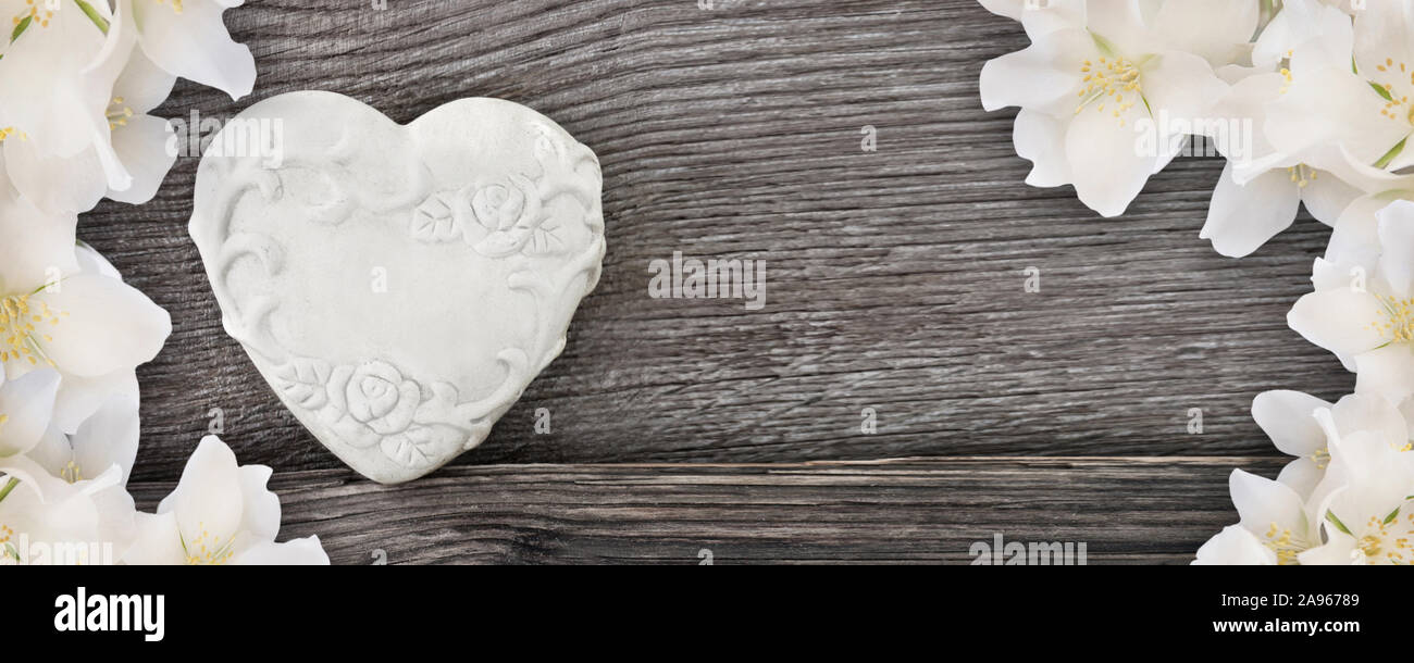 Herzen und Blüte gegen Holz- Hintergrund Stockfoto