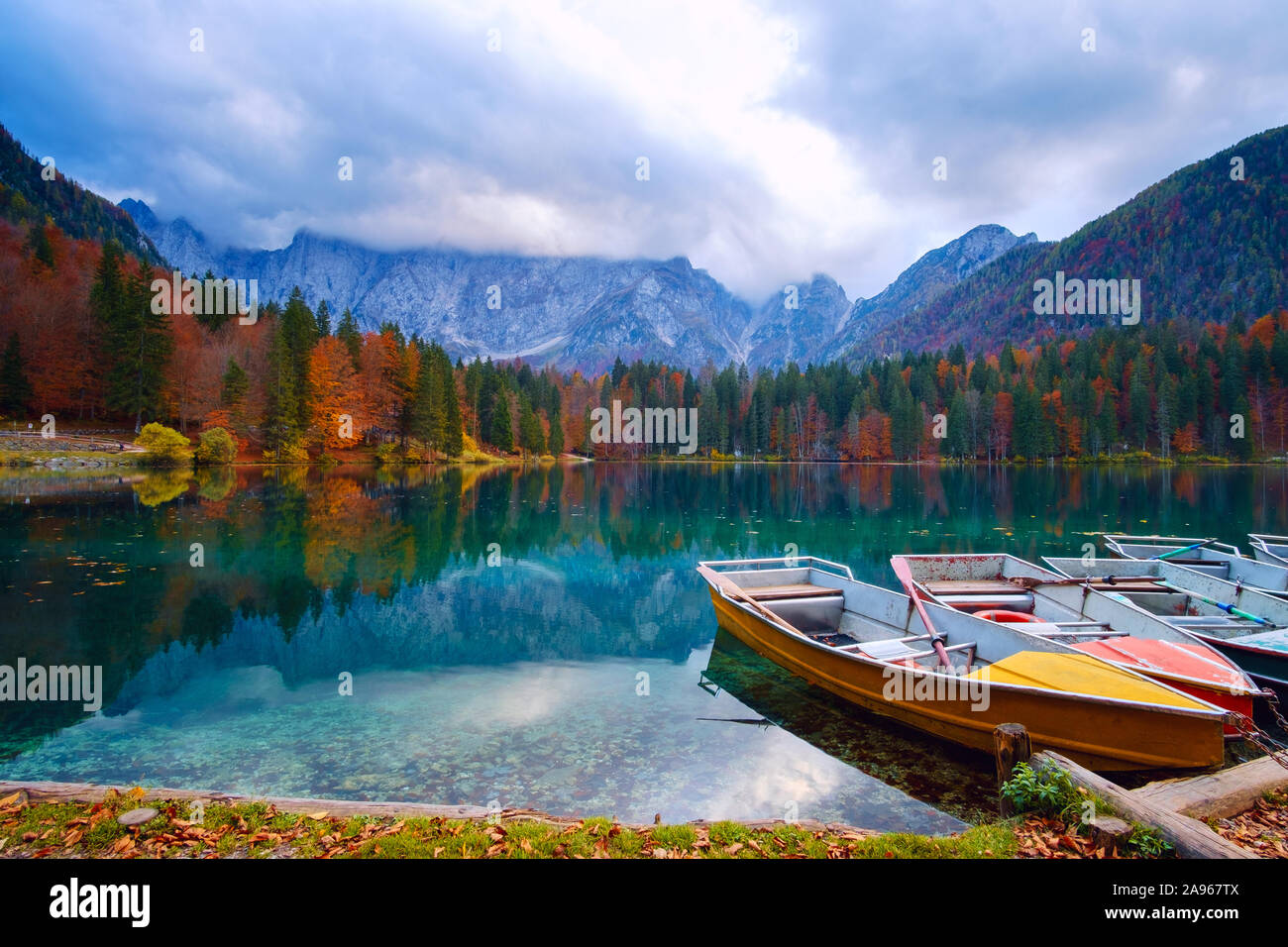 Alpine Lake und bunte Boote in der Nähe von Slovenian-Italy Grenze, See Fusine, Italien Stockfoto