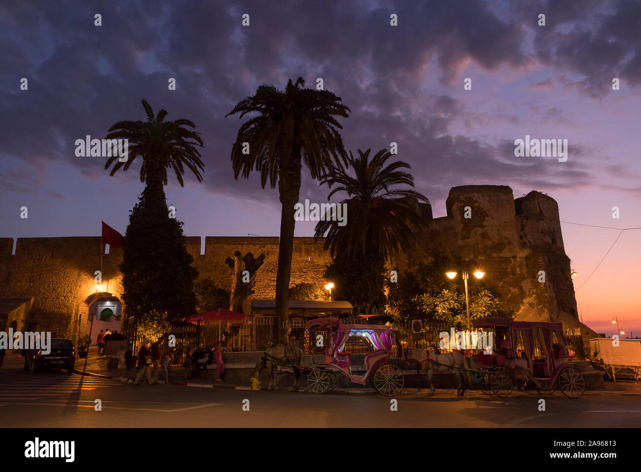 Asilah, Morocco-September 10, 2019: pferdekutschen vor der Stadtmauer des Dorfes Asilah am Abend warten auf Kunden, Marokko Stockfoto