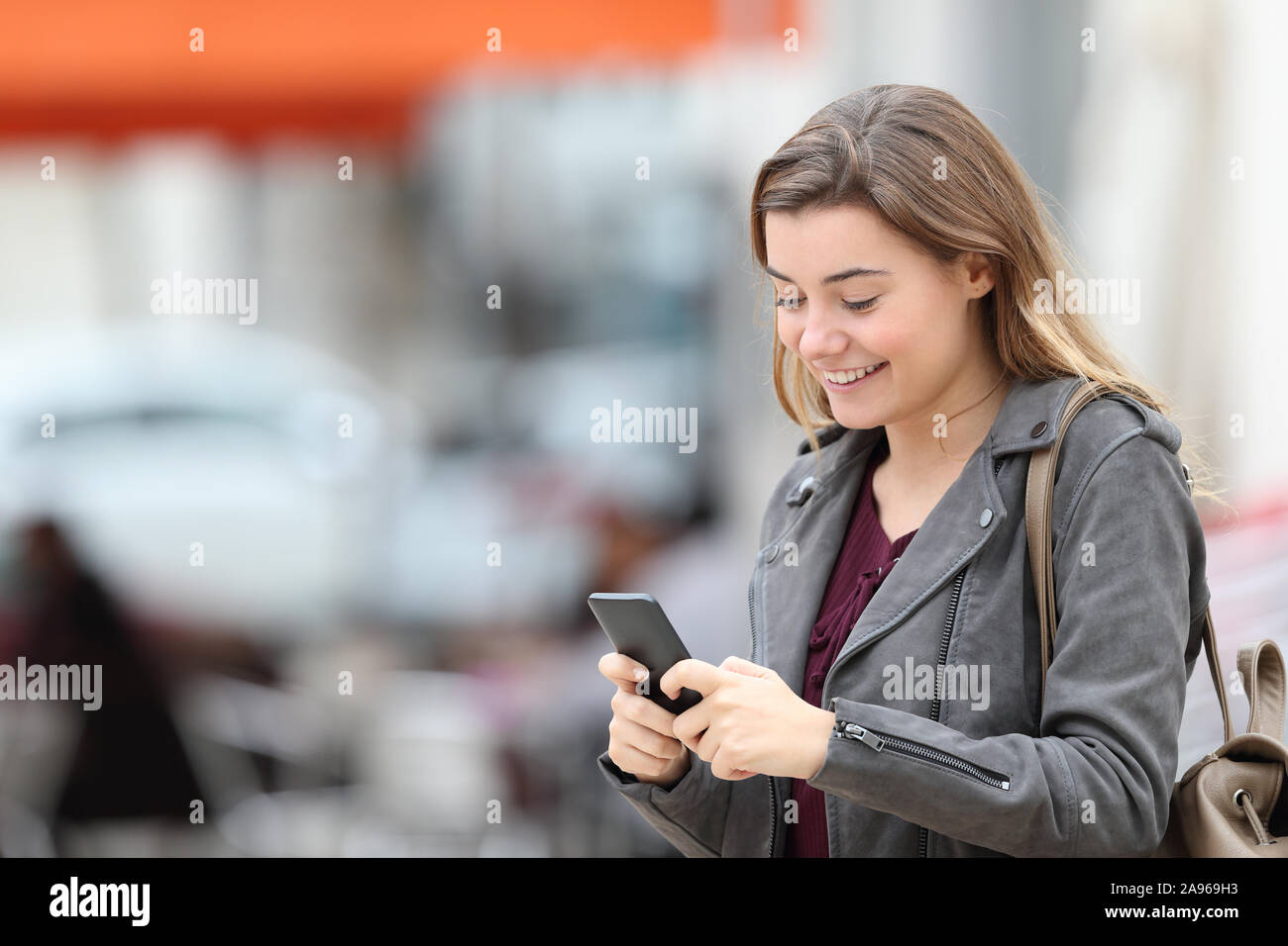 Happy Mode jugendlich SMS auf Handy allein zu Fuß auf der Straße Stockfoto