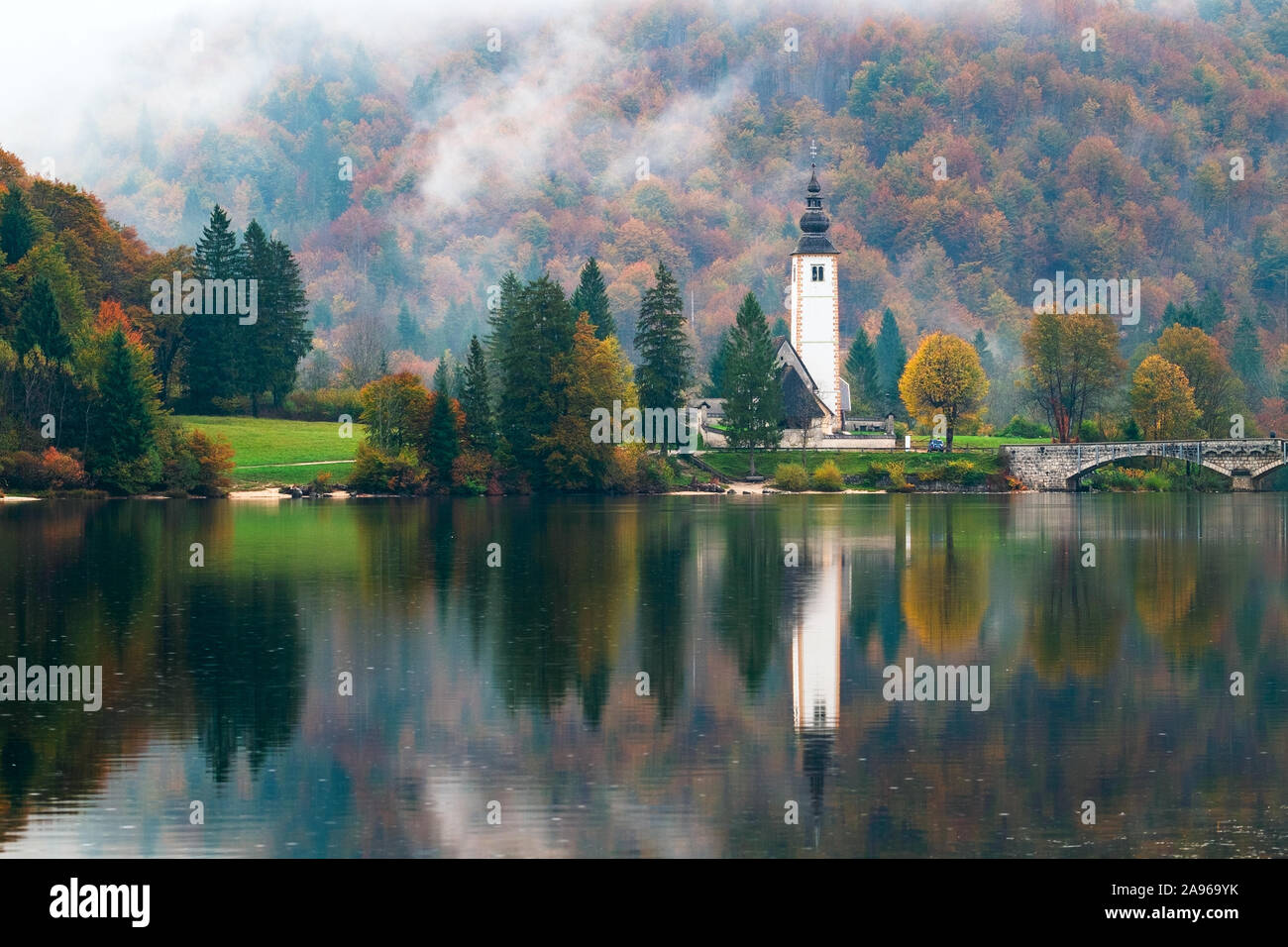 Nebeliger Morgen im Herbst am See Bohinj in Nationalpark Triglav, Slowenien Stockfoto