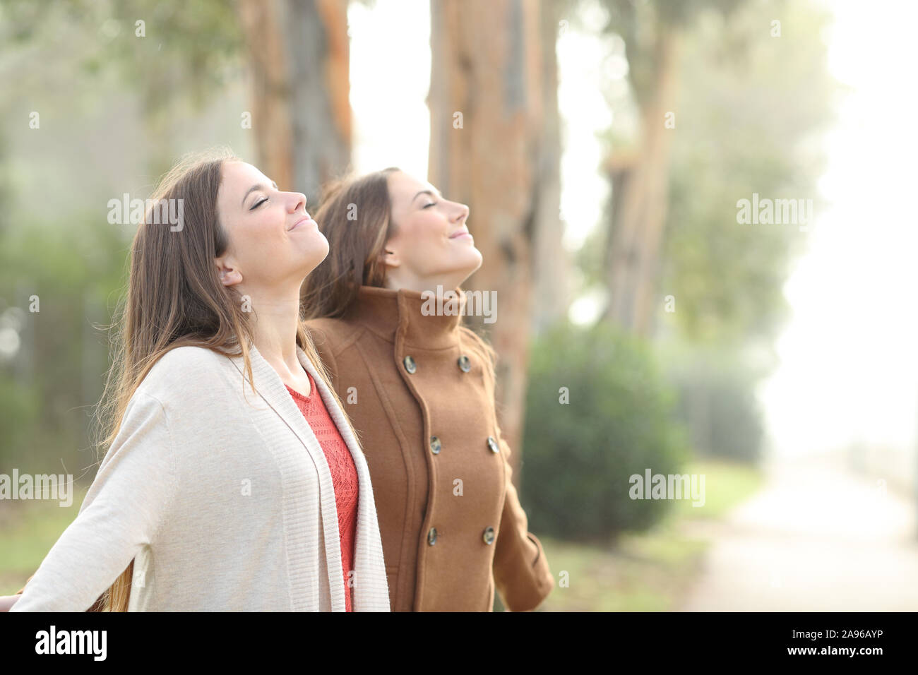Zwei Frauen entspannt atmen tief die frische Luft stehend in einem Park Stockfoto