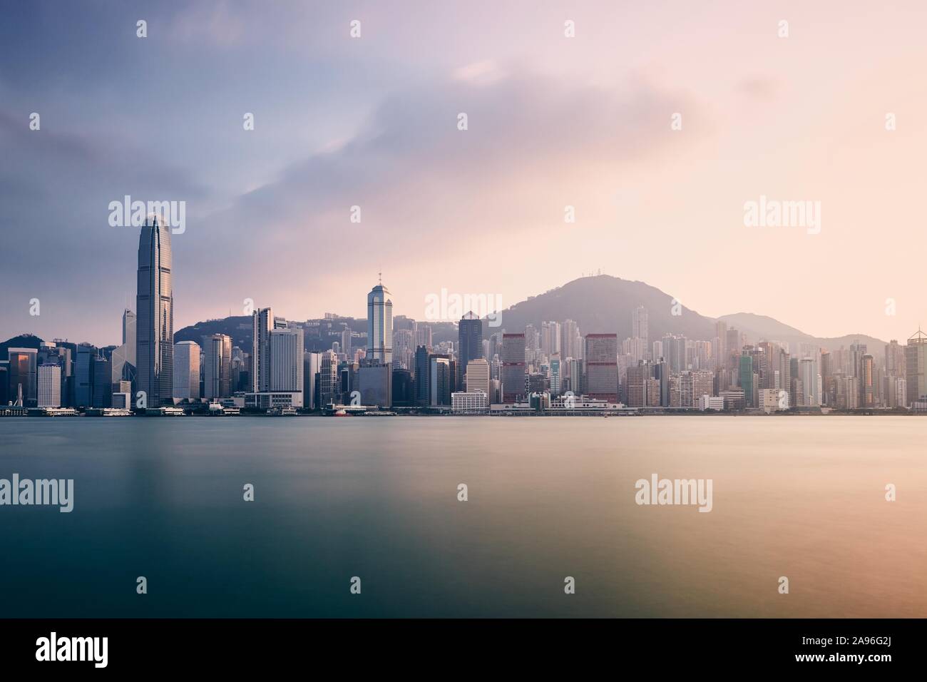 Moderne Stadt bei Sonnenuntergang. Victoria Harbour und die Skyline der Stadt mit Wolkenkratzern, Hong Kong. Stockfoto