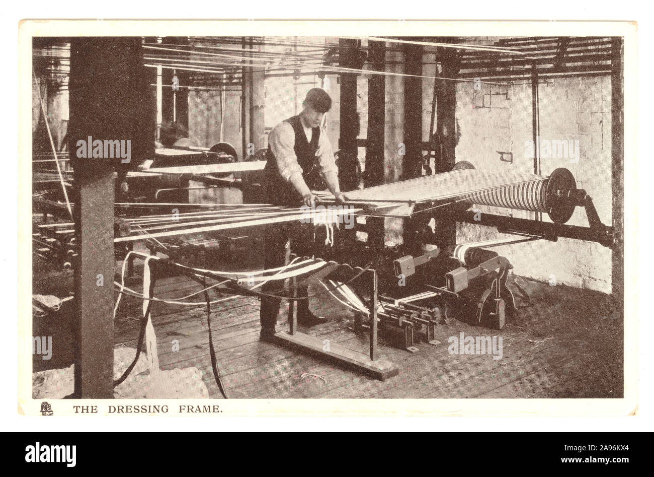 Postkarte aus dem frühen 20. Jahrhundert eines Mannes, der in einer Baumwollfabrik am Kleiderrahmen arbeitete - Lancashire, England, Großbritannien, um 1909. Stockfoto