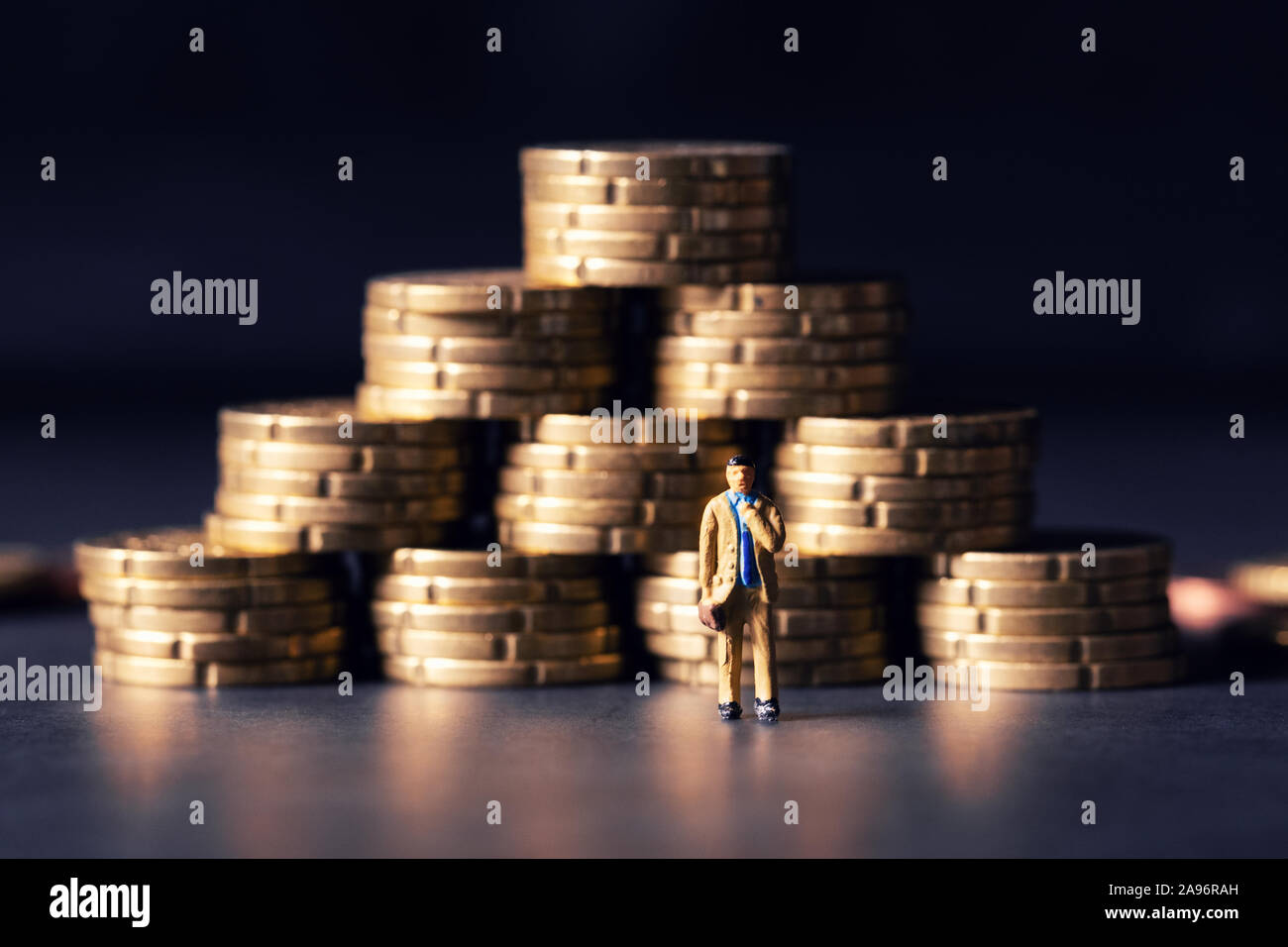 Geld, Wachstum und Erfolg eines Unternehmens Konzept. Geschäftsmann Figur mit Münzen Pyramide Stockfoto
