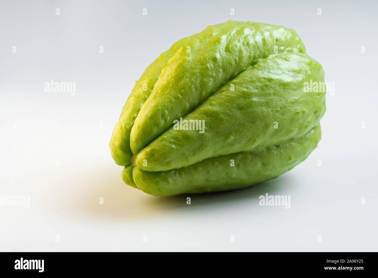 Nahaufnahme von frischen grünen Chayote isoliert auf weißem Hintergrund, Low Angle. Exotische Lebensmittel, Ernährung und Vegetarismus. Stockfoto
