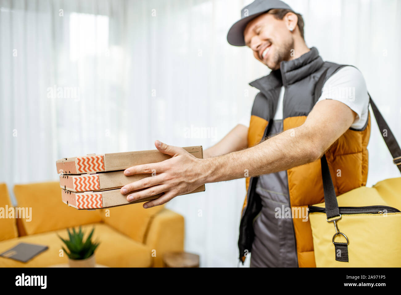 Professionellen Kurierdienst in Uniform holding Pizzakartons, Lieferung von Nahrung home Stockfoto