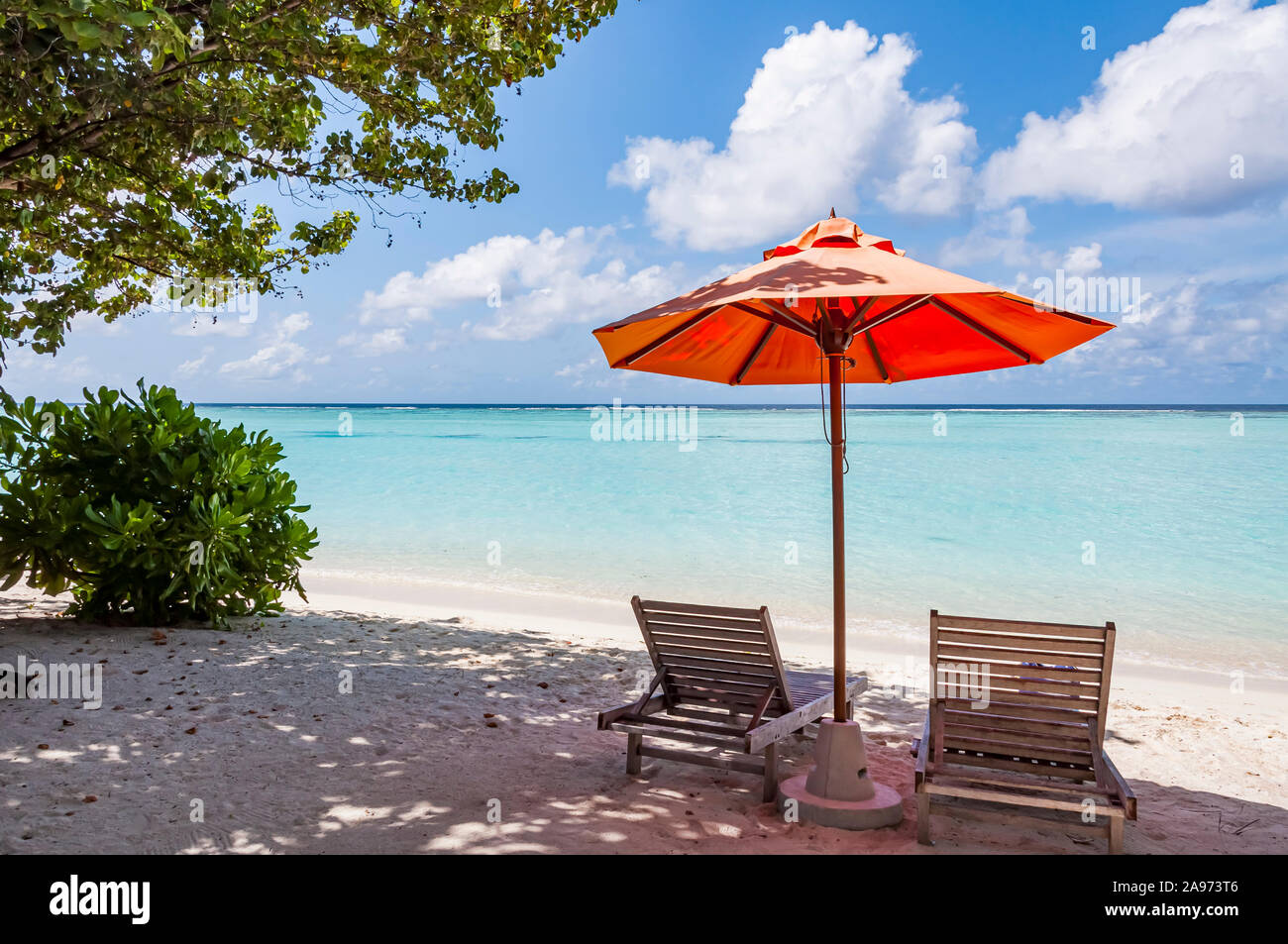 Am Strand Liegestühle mit Sonnenschirm von Orange Stockfoto