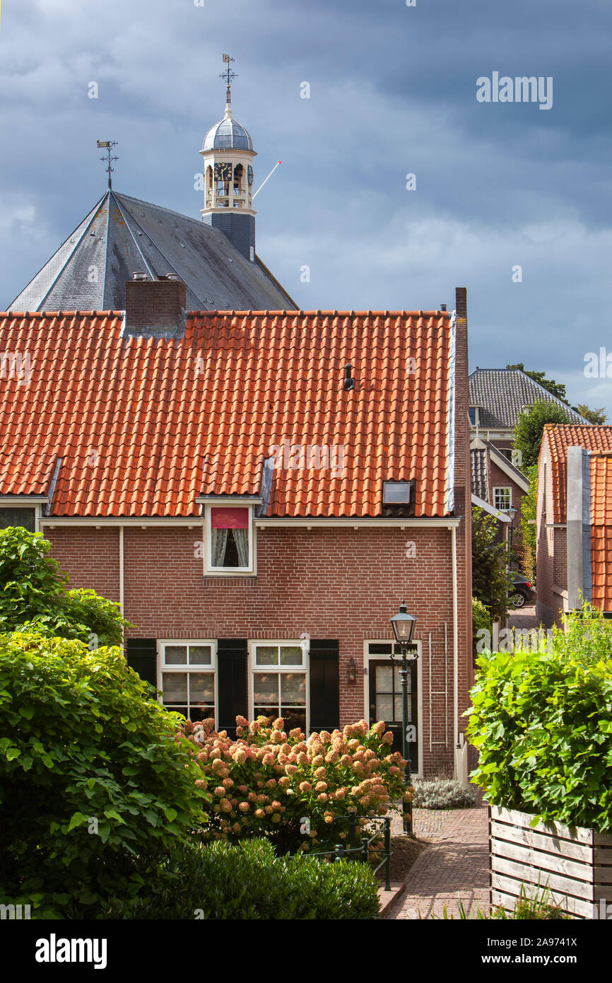 Die traditionellen roten Ziegeldächern und der Turm der Kirche in Nieuwpoort in den Niederlanden Stockfoto