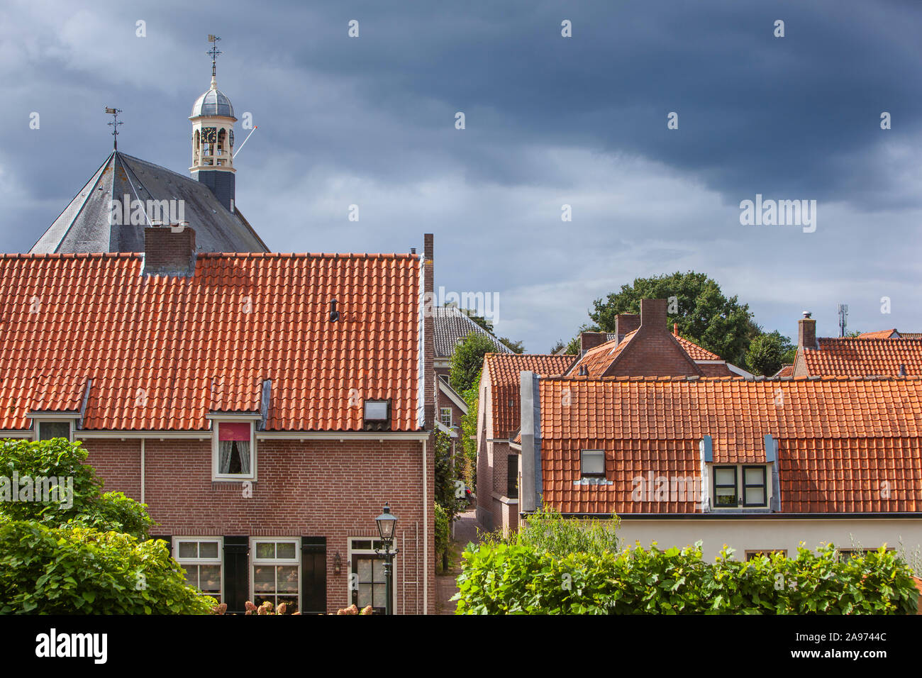 Die traditionellen roten Ziegeldächern und der Turm der Kirche in Nieuwpoort in den Niederlanden Stockfoto