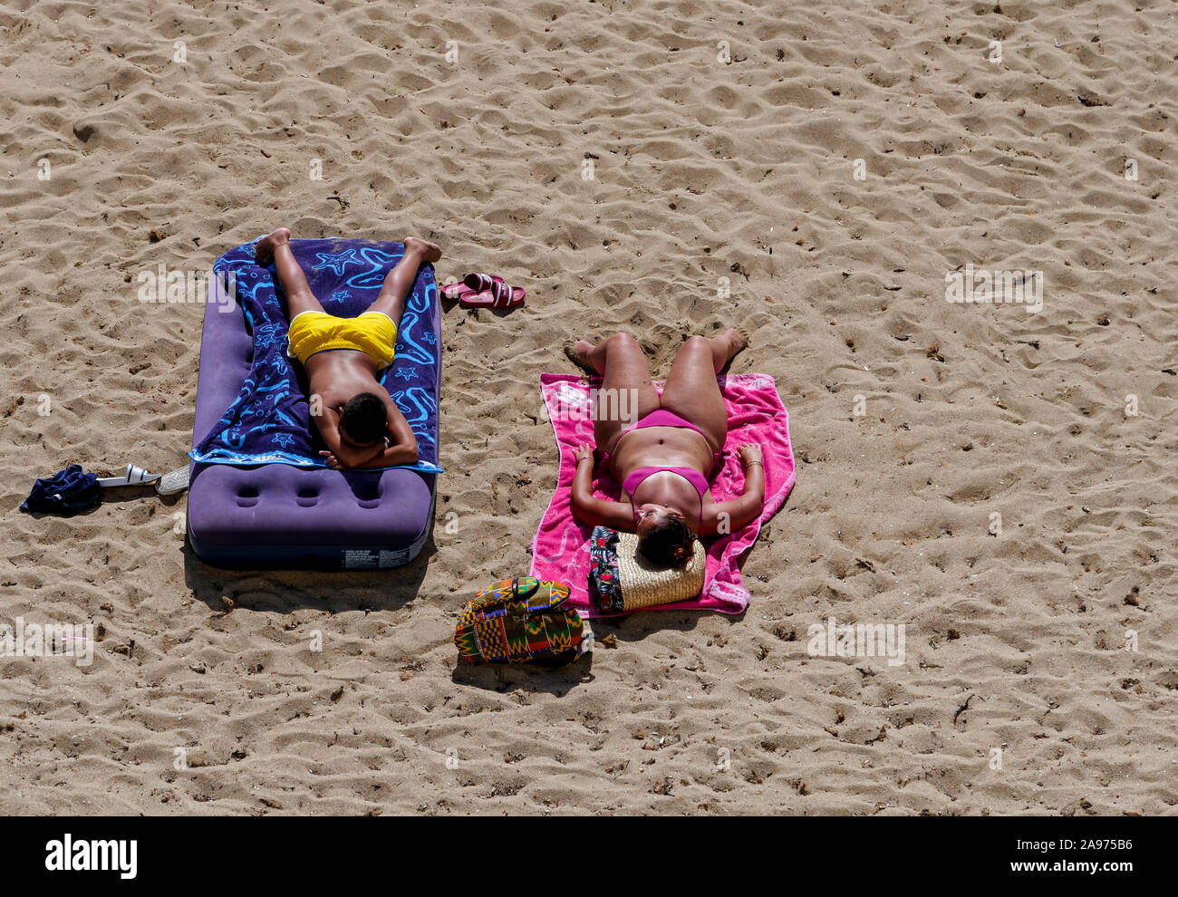 Sonnenbaden Leute am Strand liegen auf Bunte Handtücher der mediterranen Hafen am tiefblauen Meer Stockfoto
