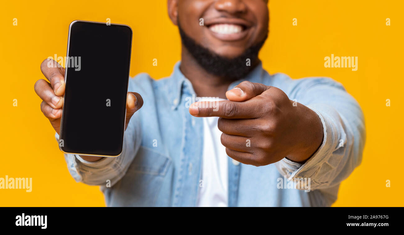 Nicht erkennbare afro Kerl Holding mit schwarzen Bildschirm Smartphone und verweist darauf, selektiver Fokus auf die Hände mit Telefon, Panorama Stockfoto