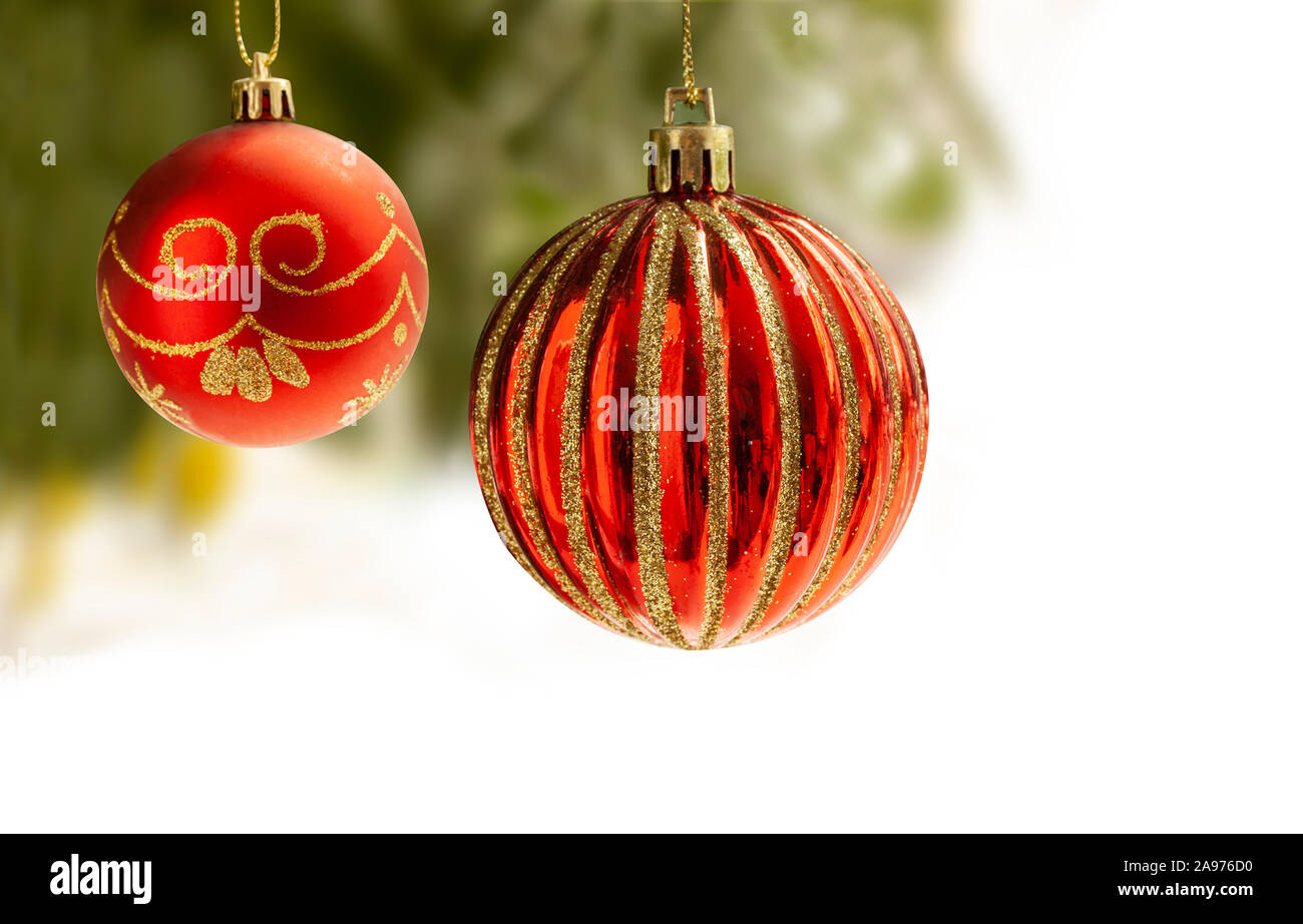 Roten Weihnachtskugeln mit gold Dekoration hängen von einem Weihnachtsbaum mit verschwommenen Hintergrund. Ball sind teilweise auf Weiß für Kopie schriftlich auf t isoliert Stockfoto