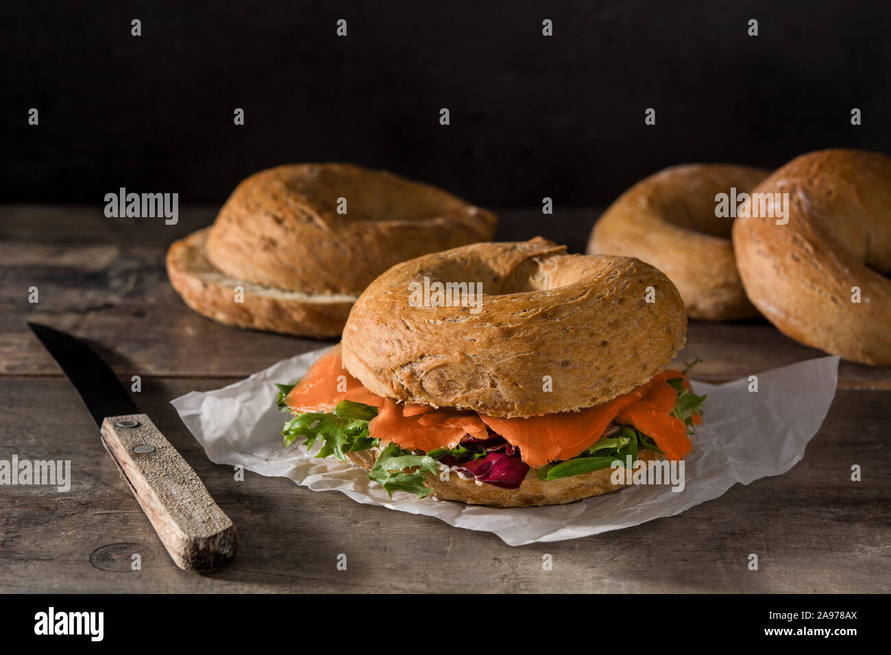 Sandwich Bagel mit Frischkäse, Lachs und Gemüse auf hölzernen Tisch Stockfoto
