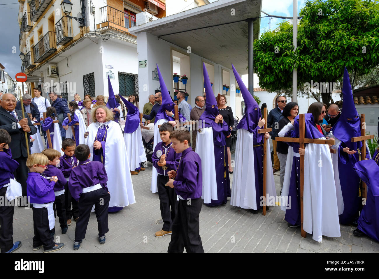 Prozession der lokalen Gemeinschaft tragen lila capirotes, tragen Jesus und das Kreuz während der Karwoche. Carcabuey, Provinz Cordoba, Andalusien. Spanien Stockfoto