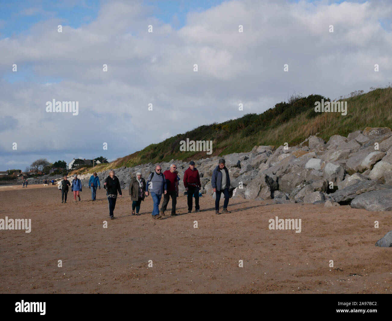 Gruppe von Menschen zu Fuß auf den Strand Stockfoto