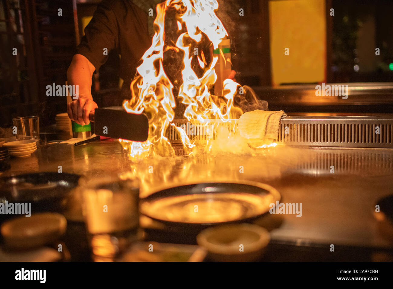Teppanyaki Küchenchef Vorbereitung Metallplatte mit Feuerflammen bereit für die Küche japanische Küche. Stockfoto