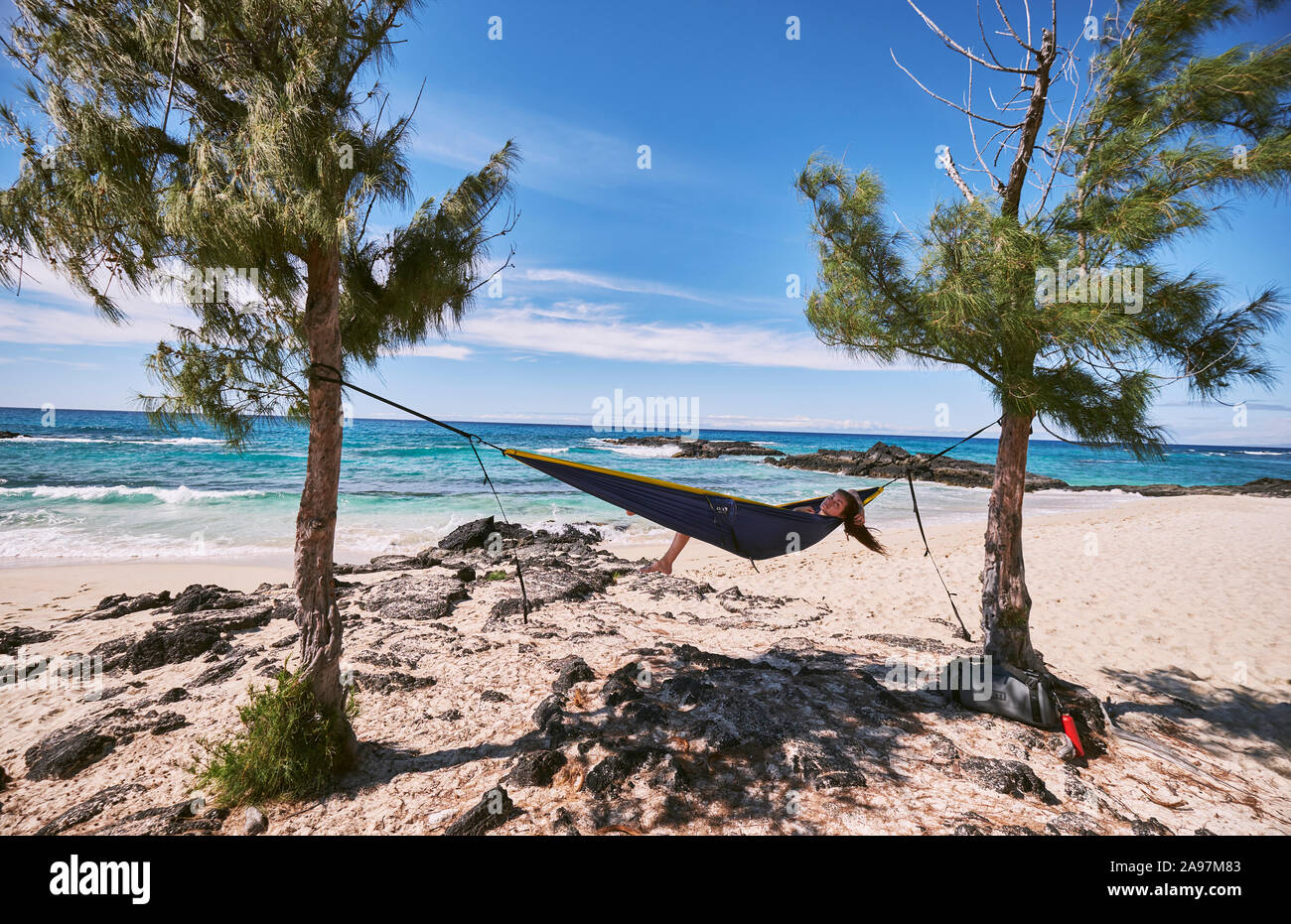 Eine Frau, die sich in Ihrer Hängematte auf Makalawena Strand, Hawaii Stockfoto